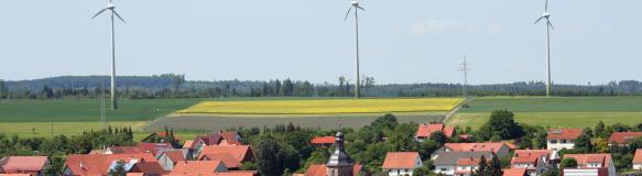 Windenergieanlagen in der Nähe einer Kommune (Bildquelle: orhch - istock)
