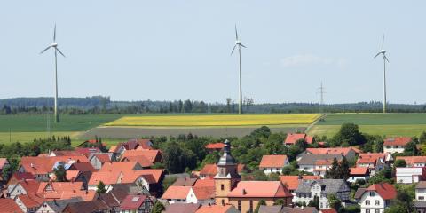 Windenergieanlagen in der Nähe einer Kommune (Bildquelle: orhch - istock)