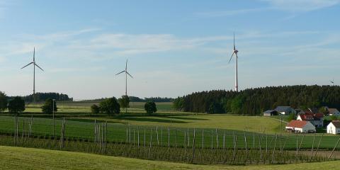 Windräder in der Landschaft neben Dorf und Wald (Bildquelle: Armin Nefzger, LfU)